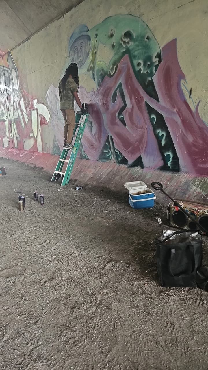 Quinton Trott painting a mural at a community event