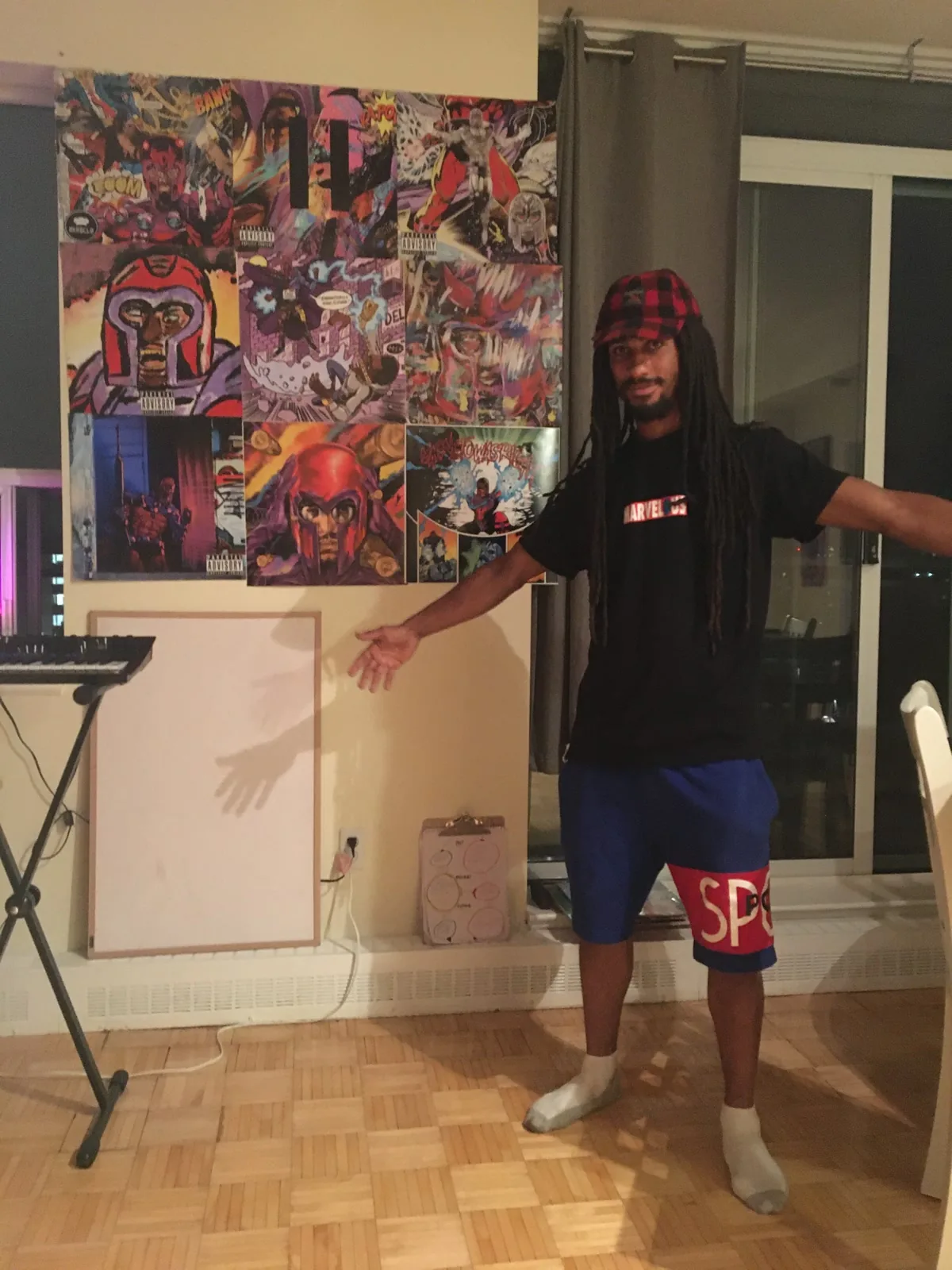 Quinton Trott standing beside a display of Raz Fresco and BKRSCLB album-cover prints he produced
